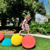 young girl hopping across bright play structure at a new playground opening this weekend in Seattle