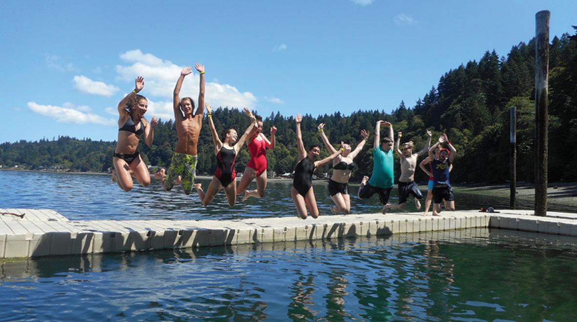 Summer campers jumping into water
