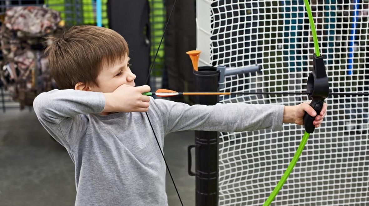 boy with bow and arrow at archery range
