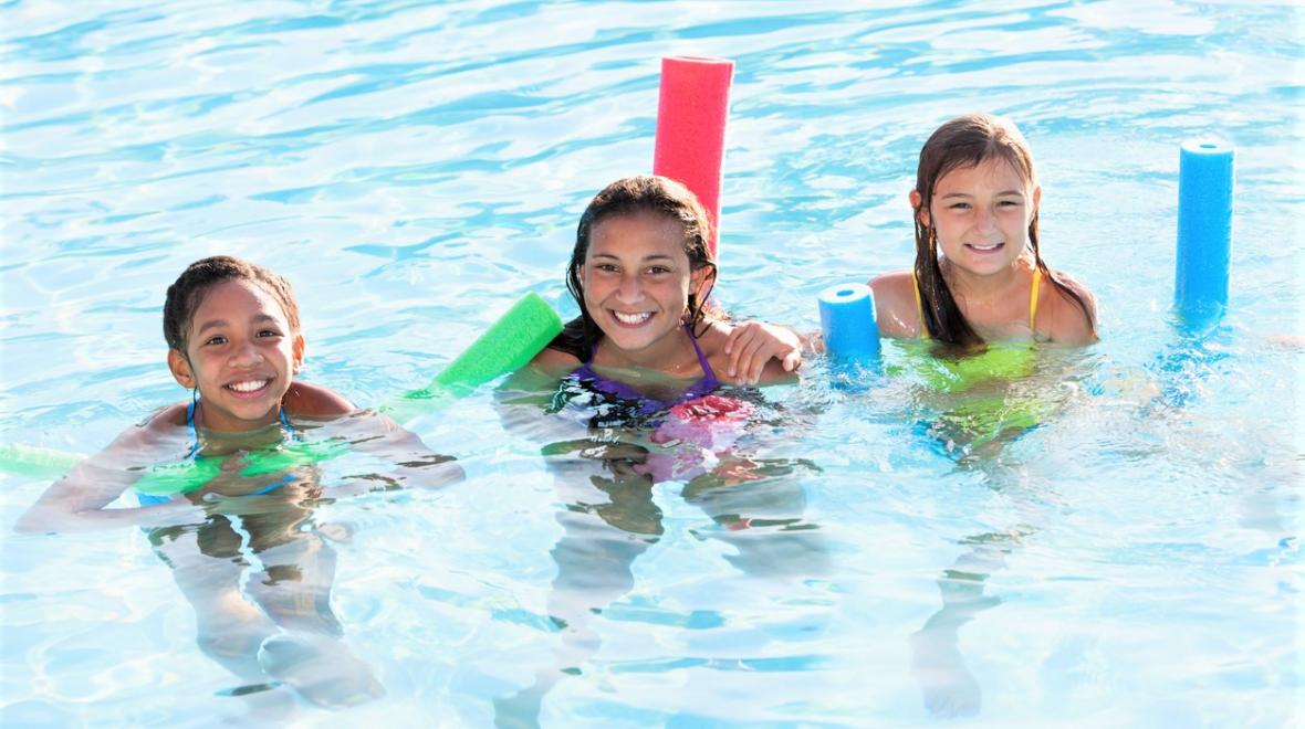 girls swimming with pool noodles