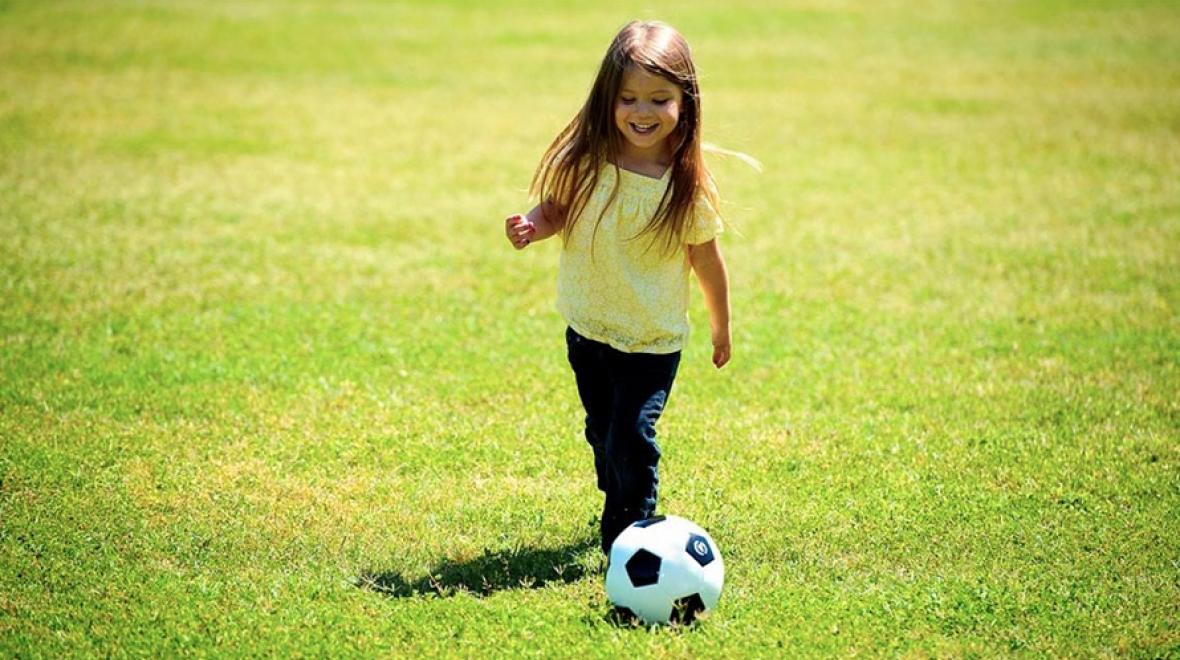Young girl kicking a soccer ball