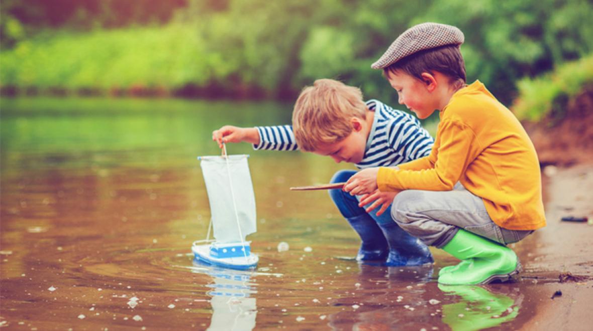 Two boys with a toy boat