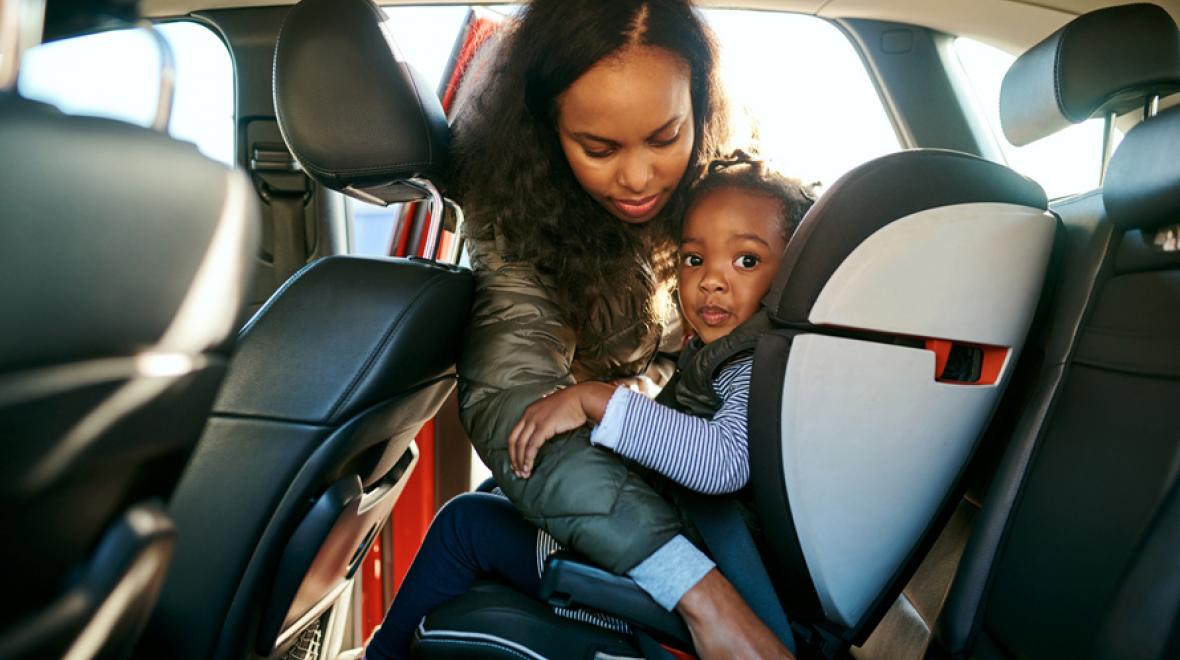 mom unbuckling daughters car seat