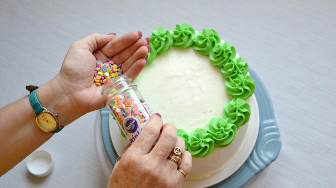 decorating a cake with sprinkles