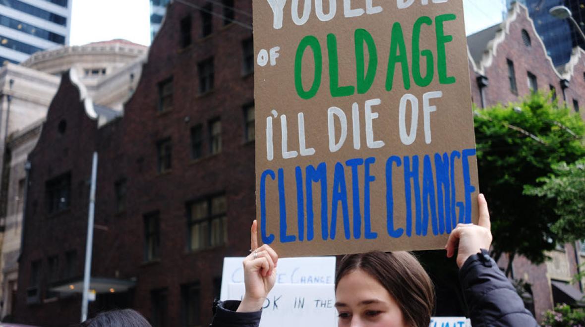 Young woman holding a sign at a climate action strike