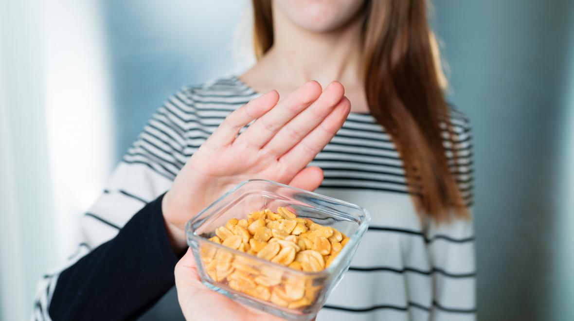 Girl pushing away a bowl of nuts