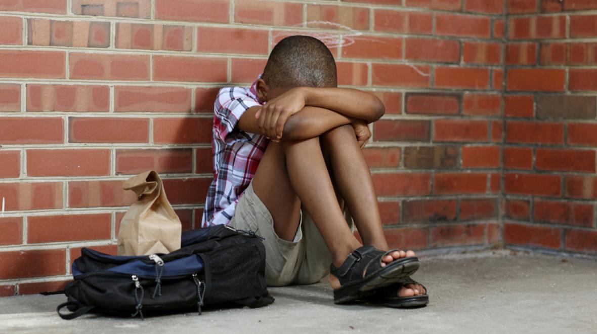 bullied boy sitting alone at school
