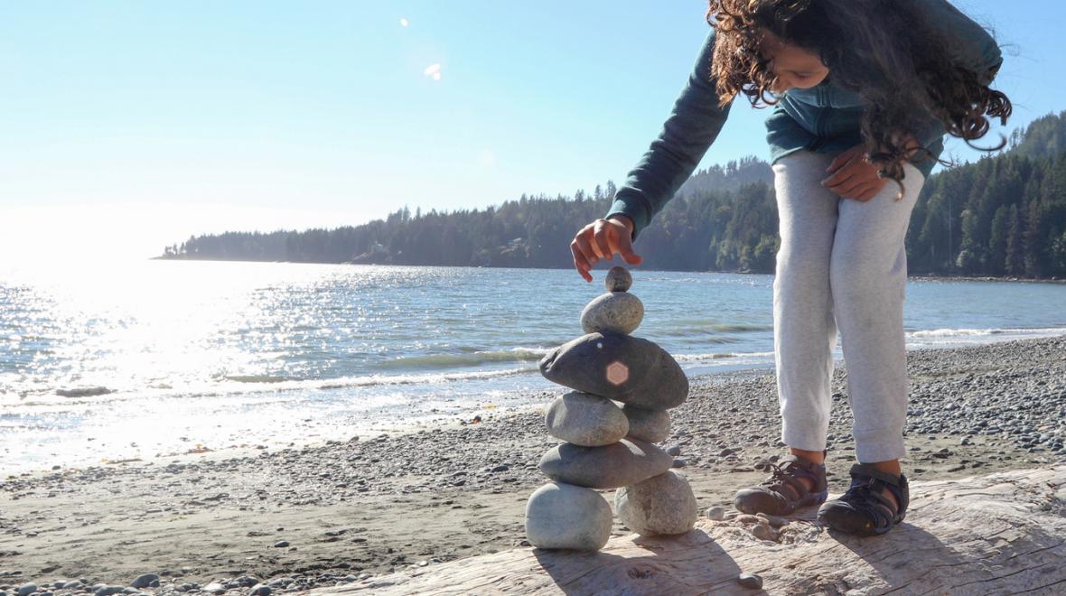 girl-building-rock-cairn-beach-nature-treasure-hunt-what-to-find-at-the-park-around-the-block