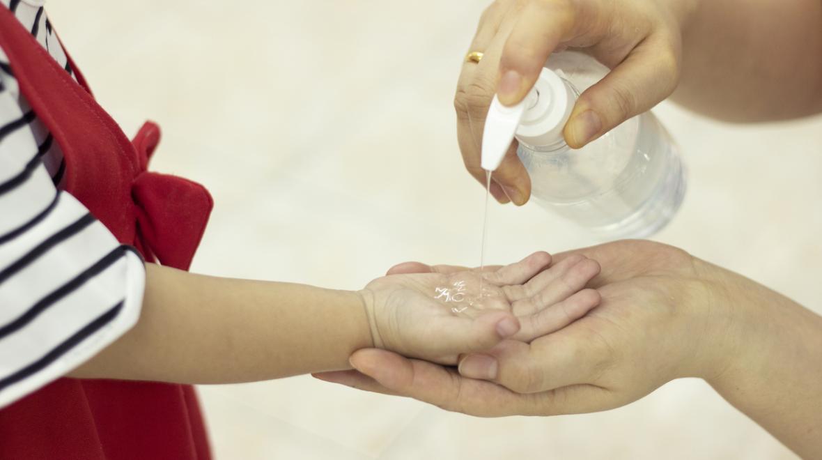 Mother and child disinfect with hand sanitizer