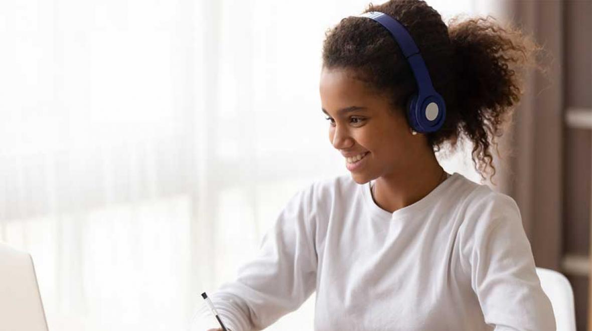 girl on computer with headphones
