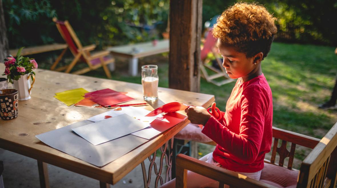 kid painting at an outdoor porch table