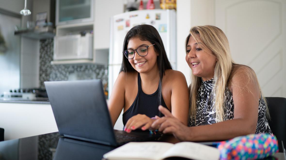 mother and daughter sitting at a laptop online learning
