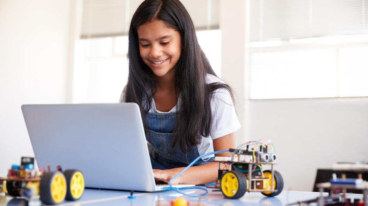 girl with a laptop and little electric vehicles and wires