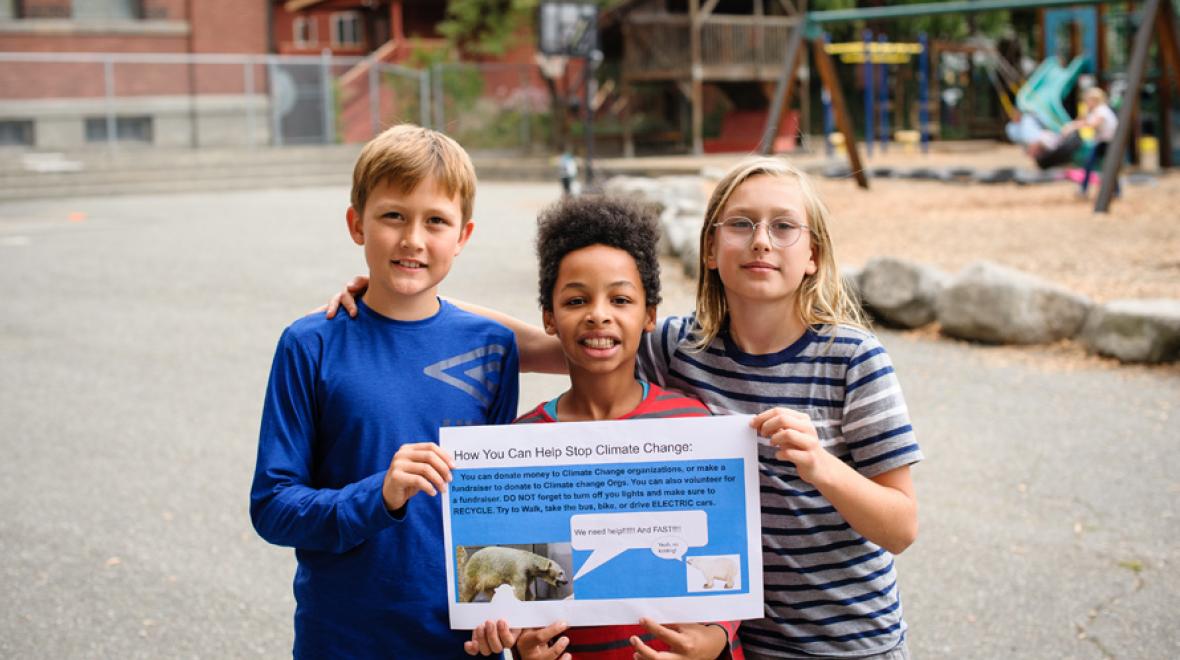 3 giddens students holding a climate change poster