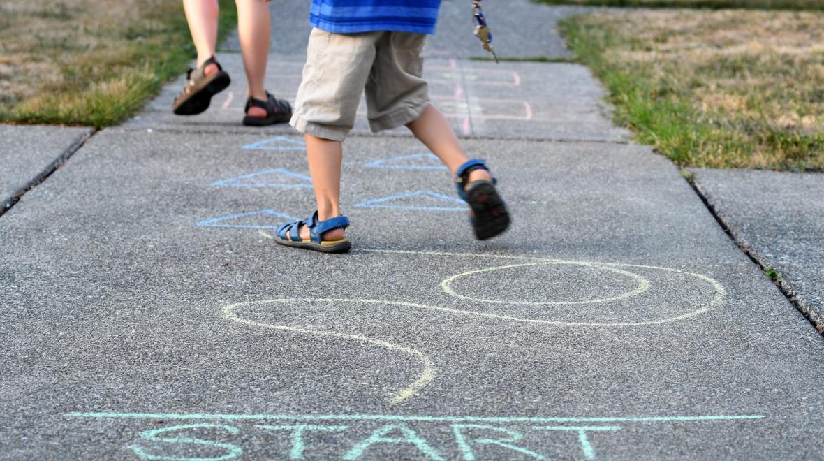boys playing on the sidewalk navigating a chalk obstacle course at-home recess ideas