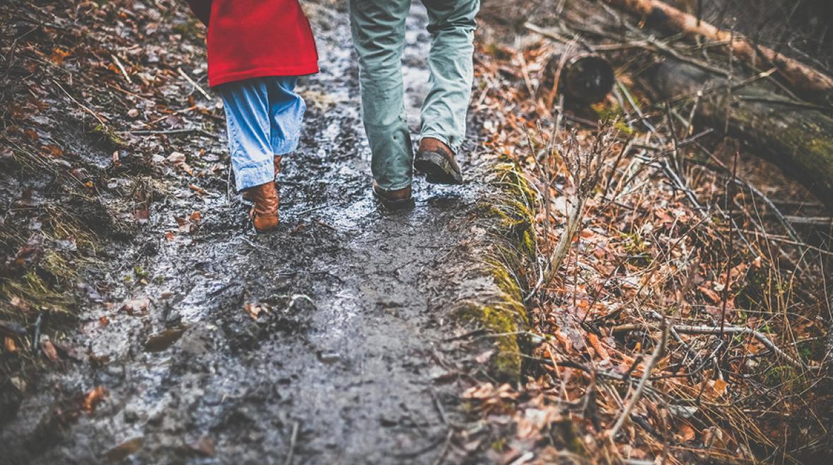 muddy path with two people's legs walking