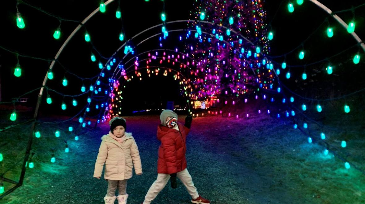 Kids standing under lighted archway at Dazzle Maple Valley light show winter 2020