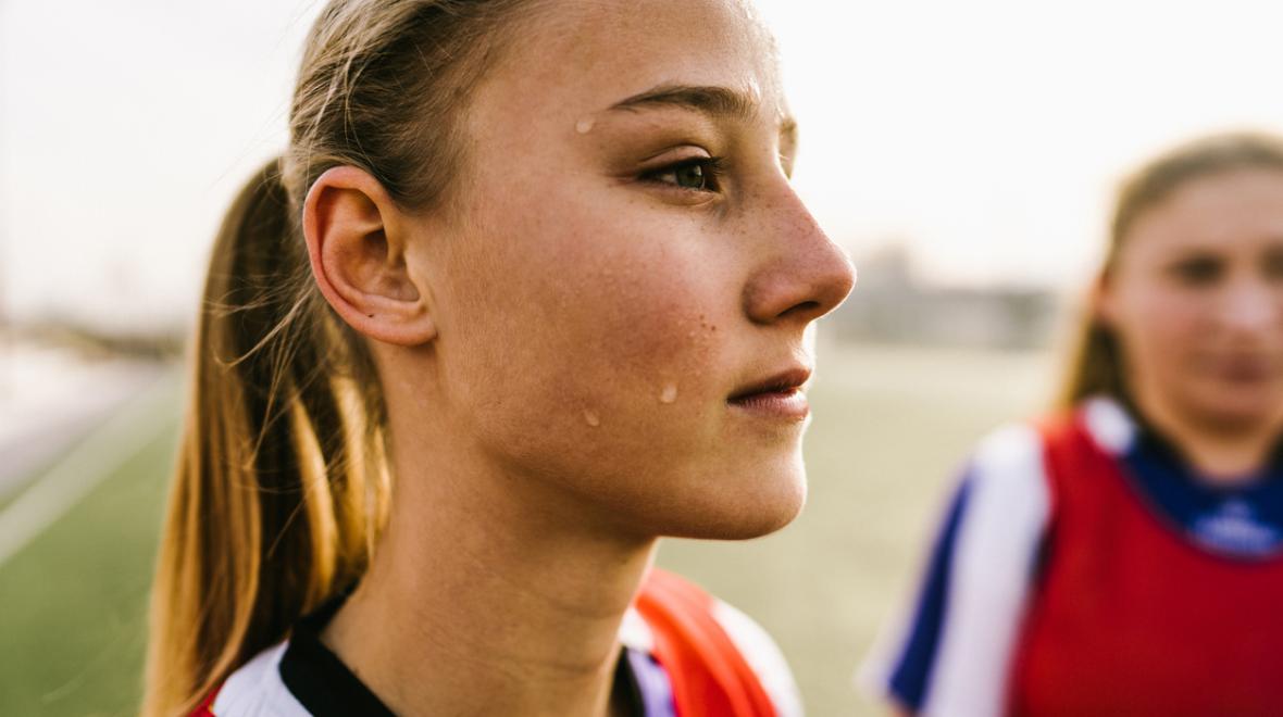closeup of a serious sporty teen girl wearing a jersey outdoors