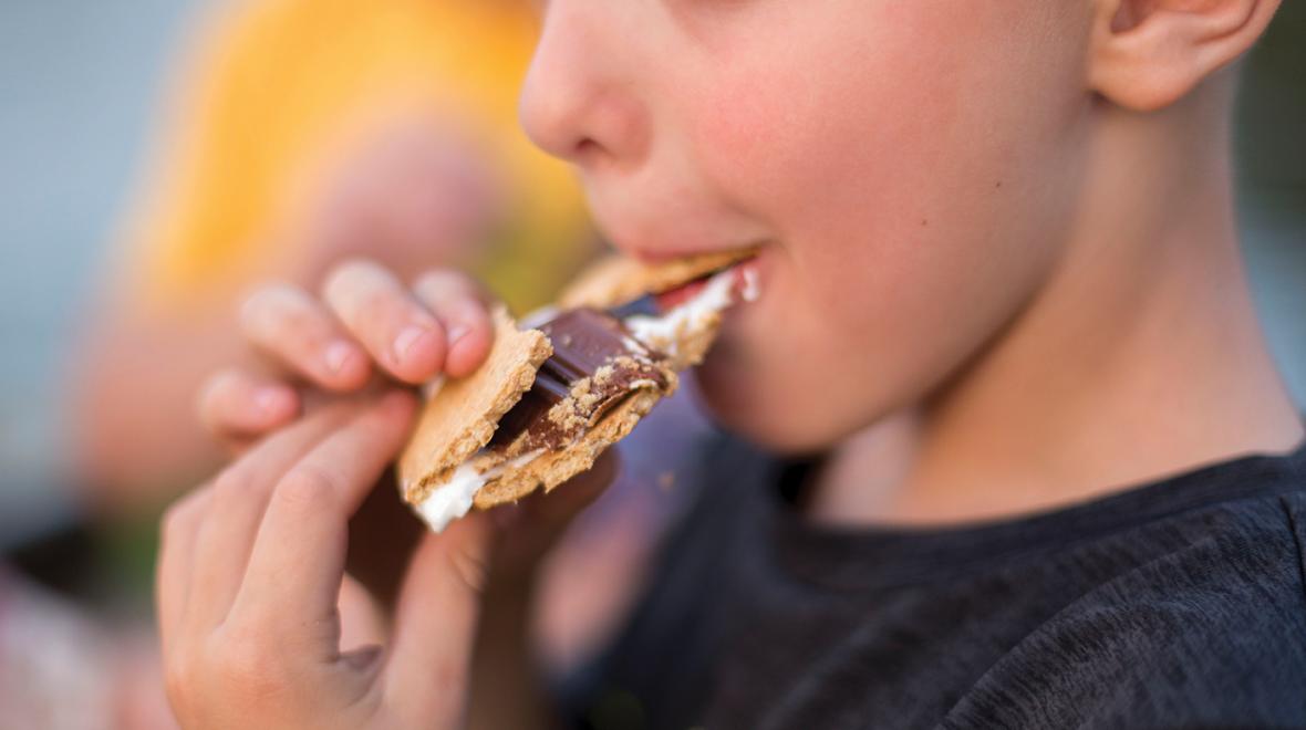 boy biting into a smore