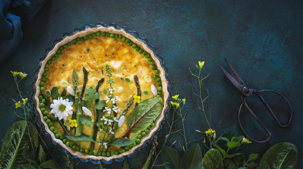 Quiche decorated with vegetables and edible flowers