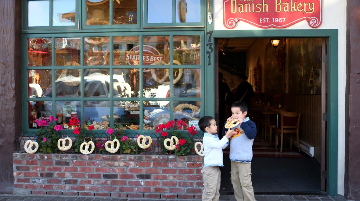 Boys enjoying a giant pretzel in front of the Danish Bakery in Leavenworth, Washington, best spring break activities for seattle area families