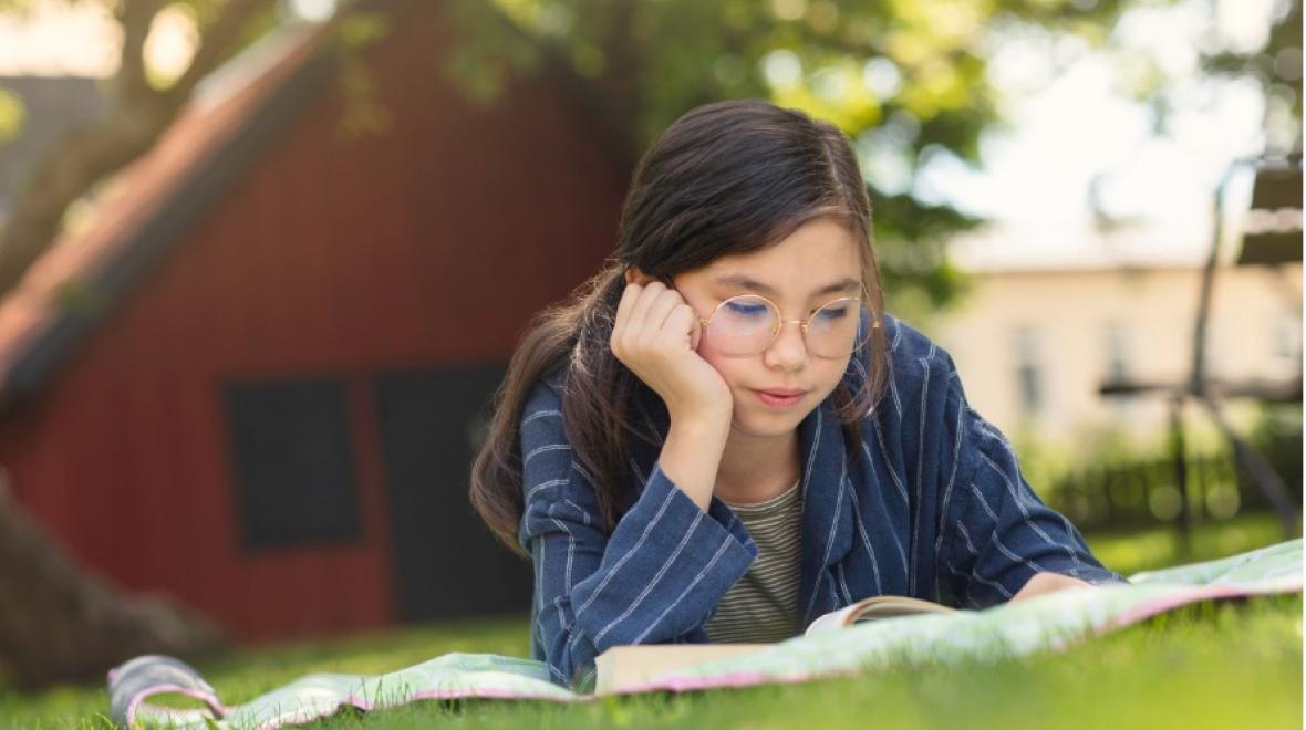 Girl reading a book outdoors