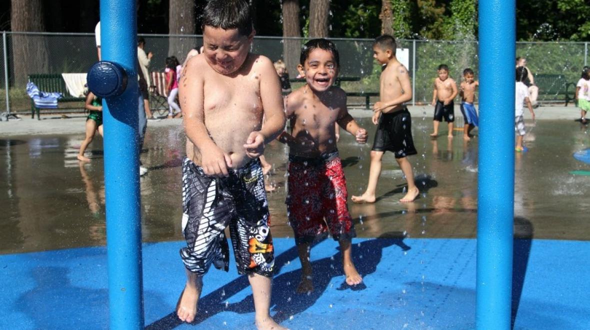 Happy kids playing at Forest Park in Everett's water playground open for summer