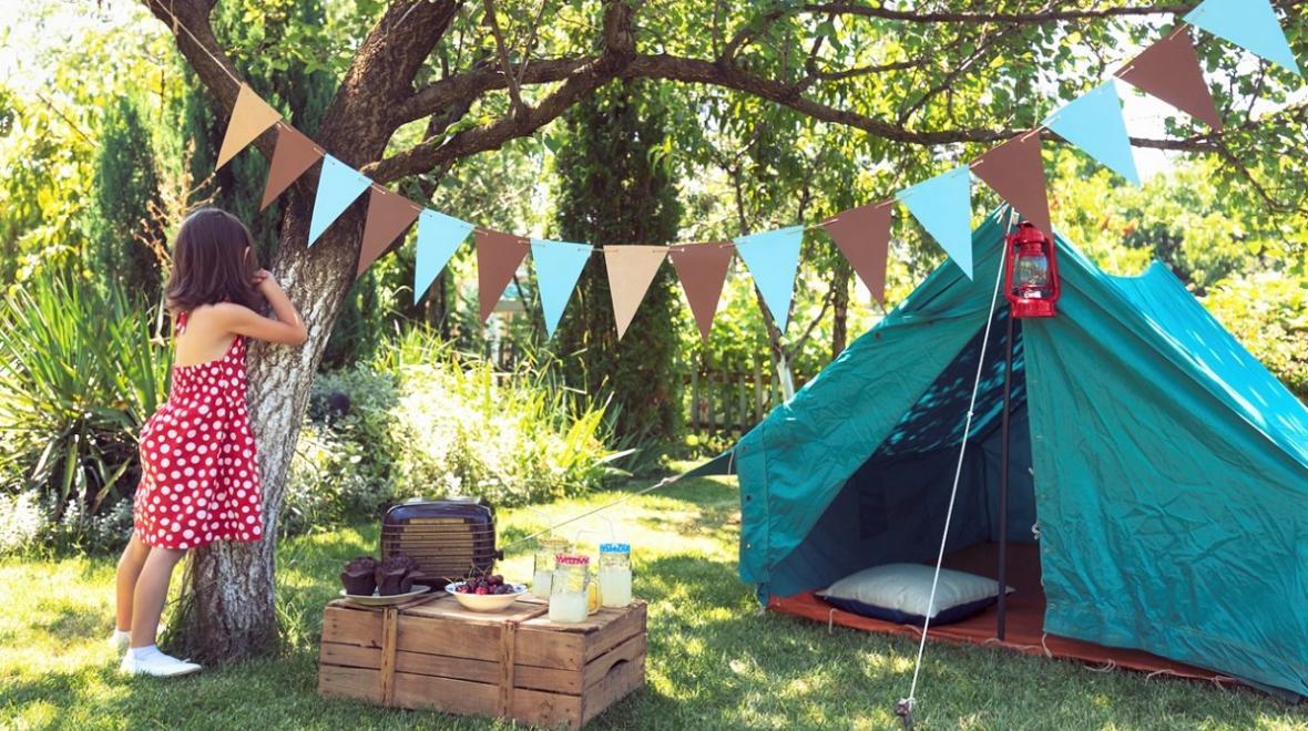 girl in the backyard with a camp tent