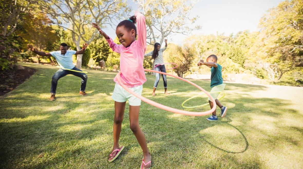 Happy girl in pink shirt hula-hooping with other Juneteenth Festival goers best Juneteenth events for Seattle-area families