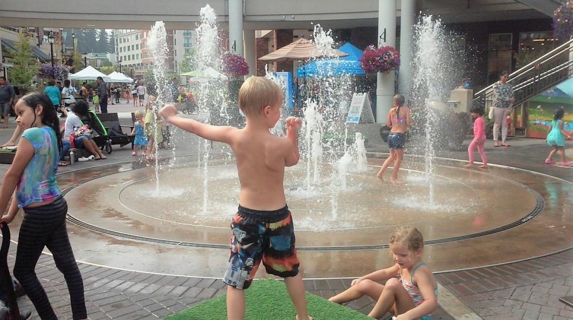 Kids playing on warm summer day at Redmond Town Center's spray splash park summer fun for Eastside families