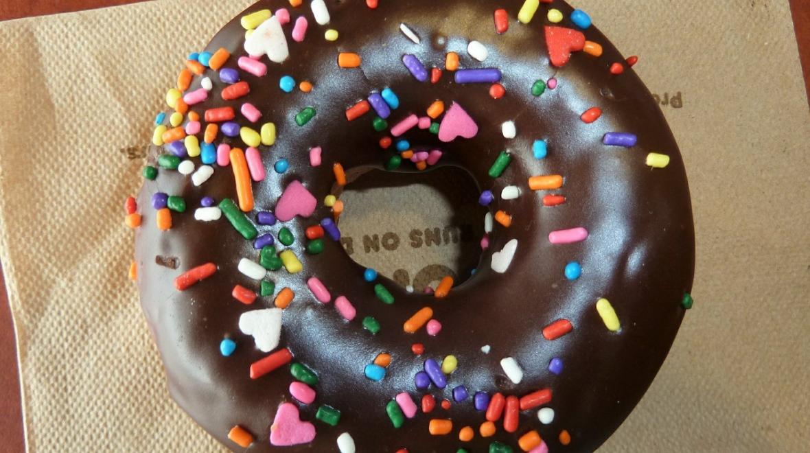 Doughnut with chocolate frosting and colorful sprinkles for National Doughnut Day freebies and deals around Seattle