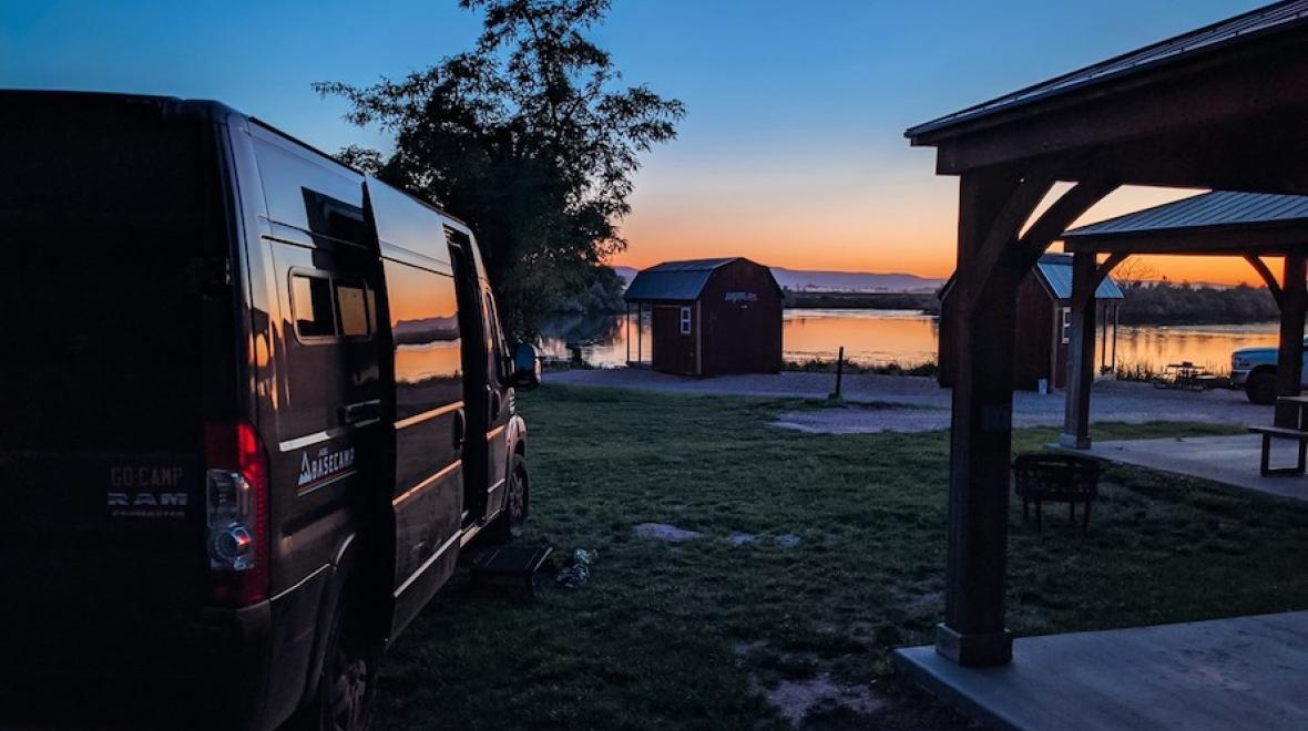 view of a camper van overlooking a sunset by a lake