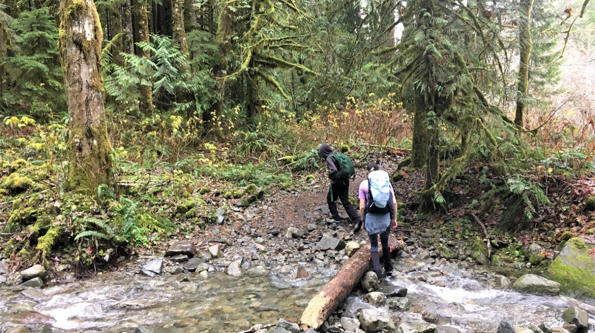 Hikers crossing the Taylor River Creek on the Taylor River trail best family hikes near SEattle along the Middle Fork Snoqualmie Road