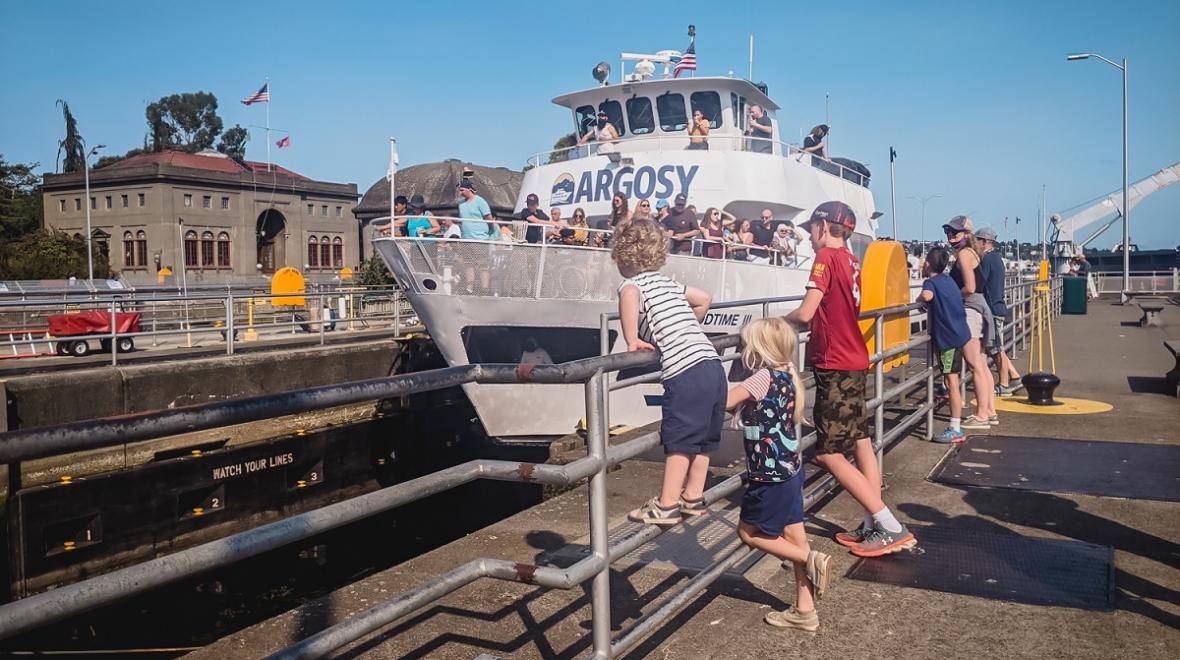 Kids at the Ballard Locks, a top tourist attraction in Seattle, watch an Argosy boat pass through the Locks from Lake Washington to Puget Sound