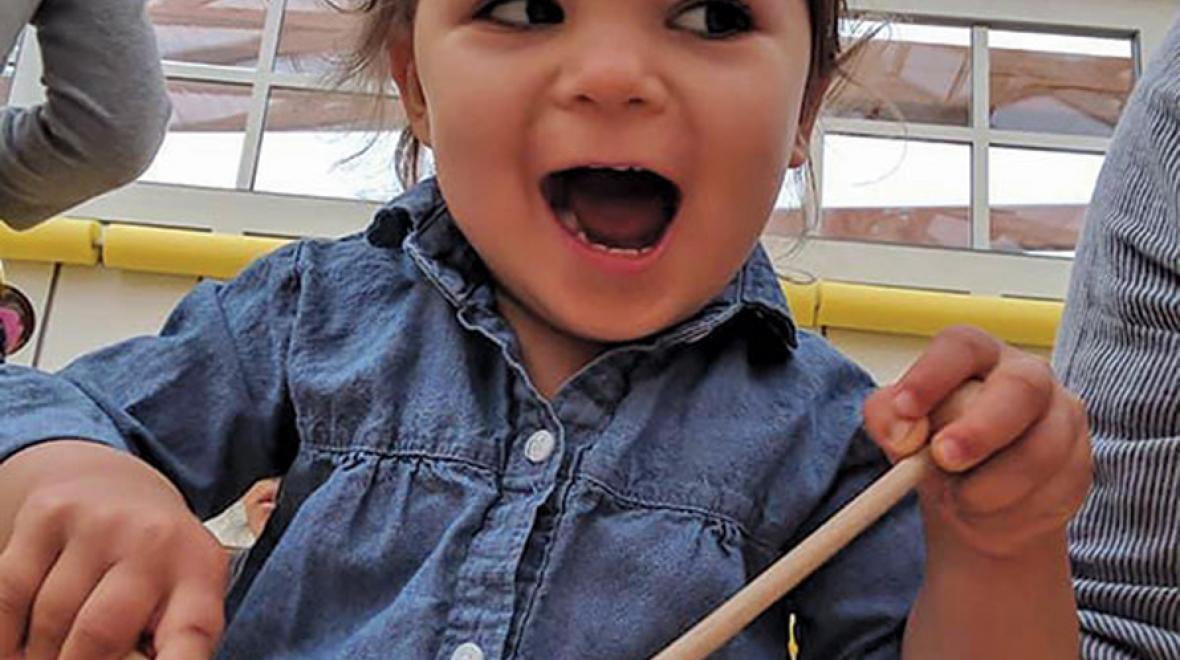 Adorable toddler playing a drum
