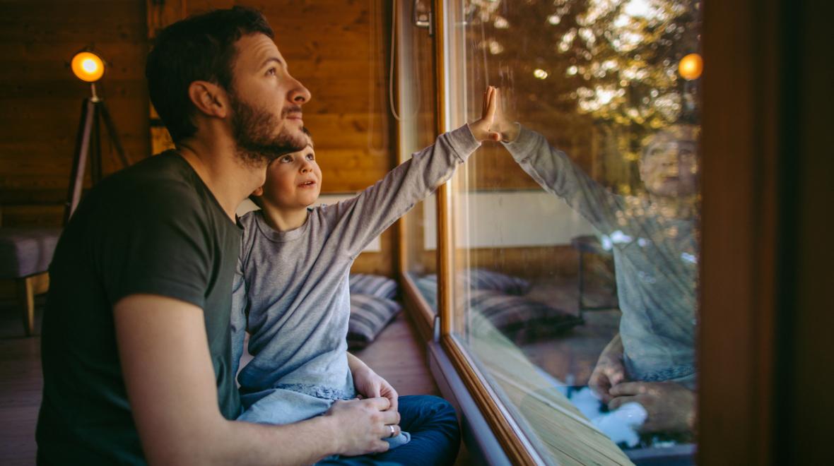 father and son sitting on a window seat in a rustic cabin