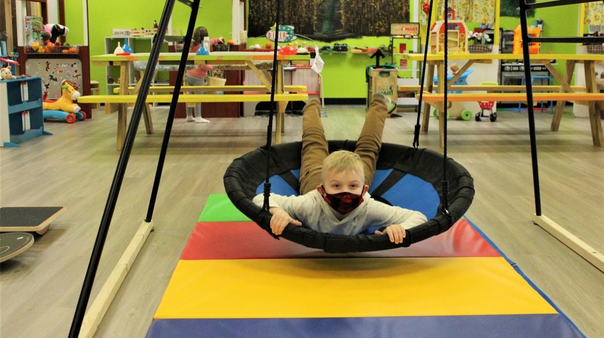 A boy plays in a ring swing at Kaleidoscope Family Play Gym in Puyallup, among the Seattle area's indoor play spaces for kids ideal for rainy-day play