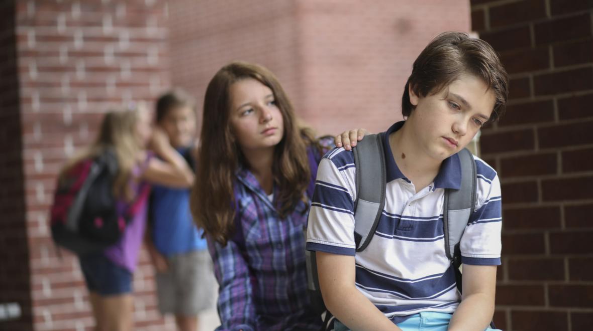 Friend comforts fellow student after he has been bullied