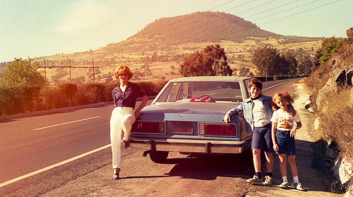 Vintage family photo standing by a car at the side of the road