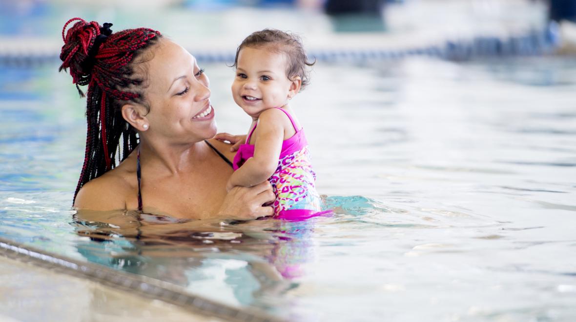 woman holding baby in a swimming pool