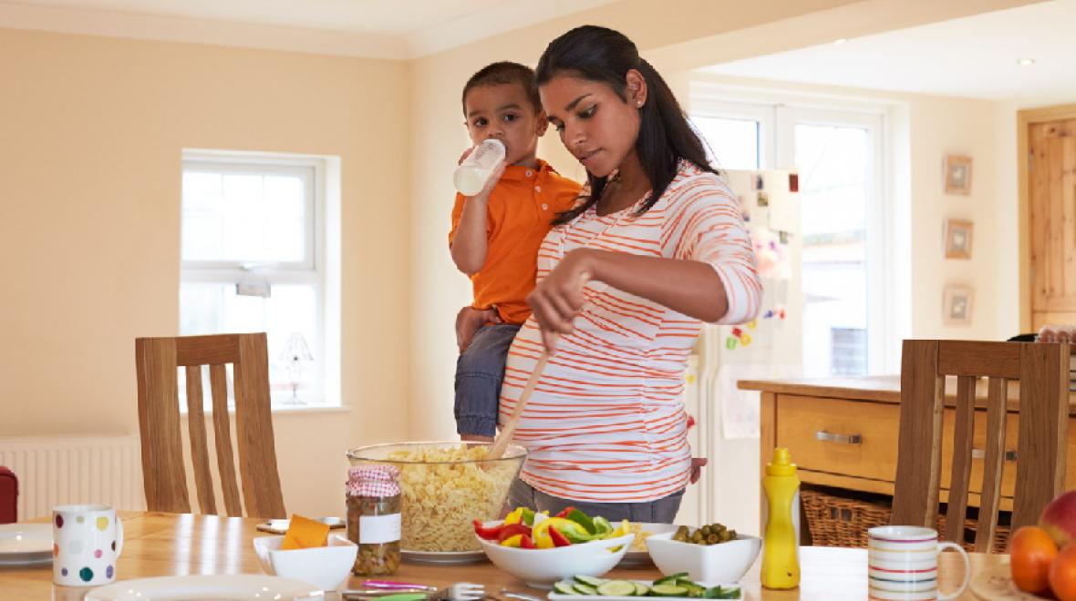 Pregnant-mother-with-toddler-making-salad