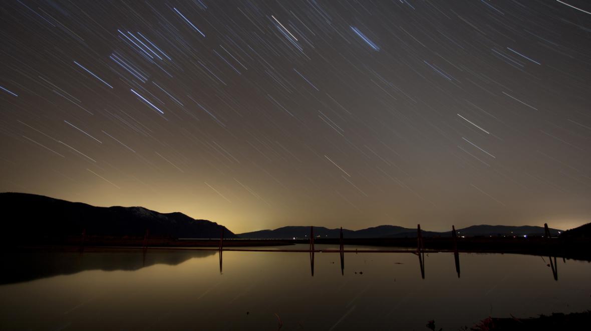 Star trails over Lake Pend Oreille in Sandpoint, Idaho, a pacific northwest road trip destination for summer mountain fun at Schweitzer and lake fun at Lake Pend Oreille