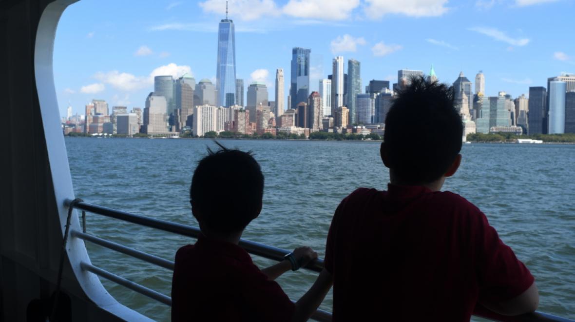 Two young children looking out from a ferry at the Manhattan skyline