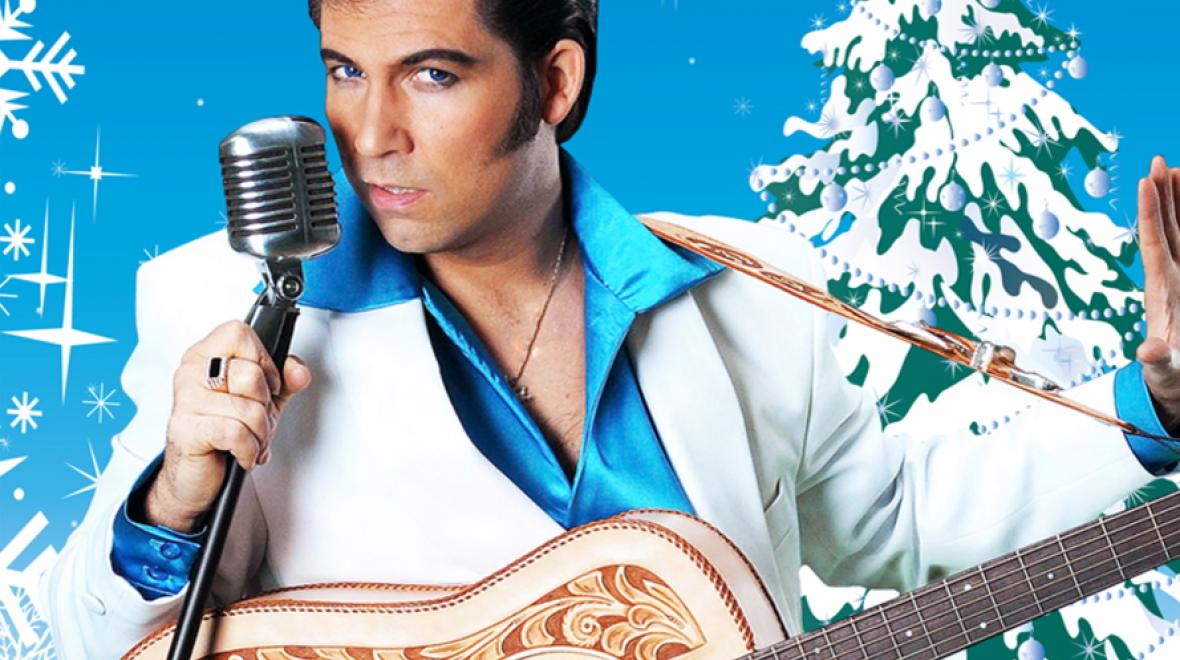 Man dressed like Elvis with a microphone and guitar