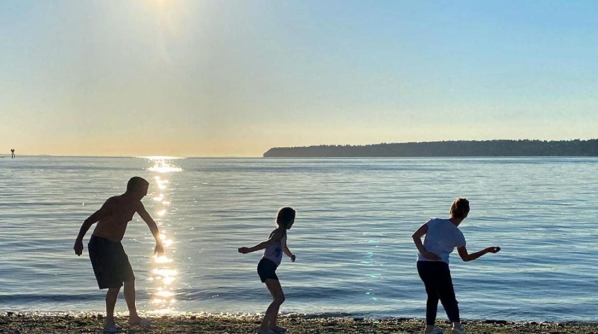 A family skips stones into Semiahmoo Bay at Semiahmoo Resort in Blaine, Washington, a fantastic family vacation destination near Seattle