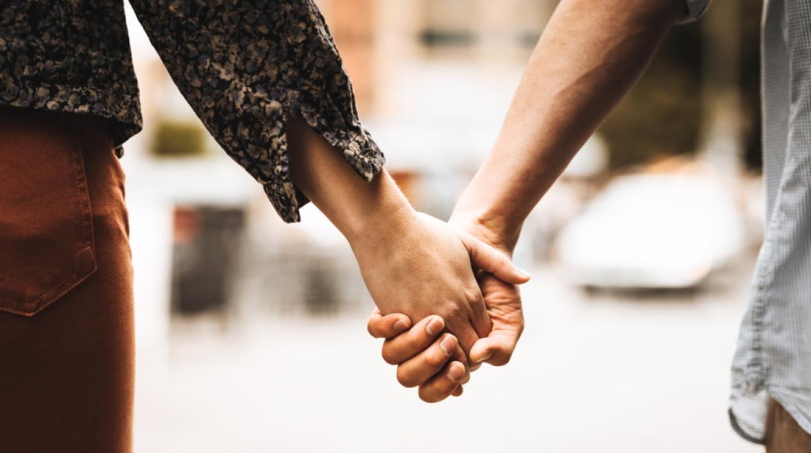 Two adults holding hands on a street