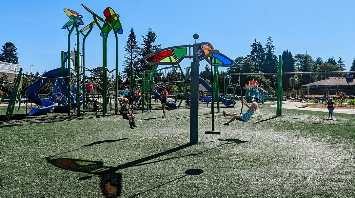 A brother and sister spin on Emma Yule Park's tri-runner, a three-seat swing spinner 