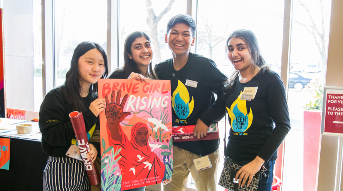 Group of teens standing together with a "Brave Girl rising" poster