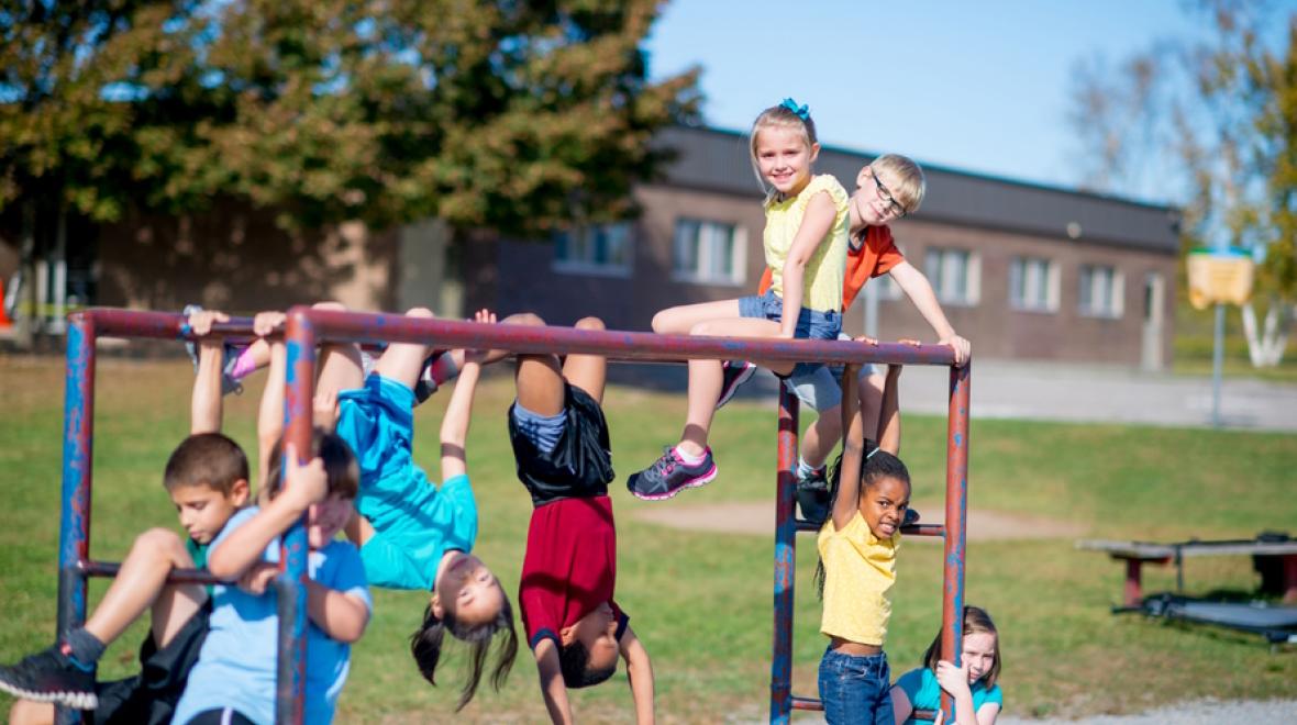 Group of children playing on a climbing structure at school