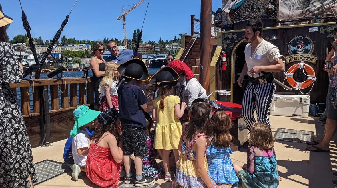 Kids gather around a pirate guide to receive training on Emerald City Pirates' Family Treasure Cruise on Seattle's Lake Union